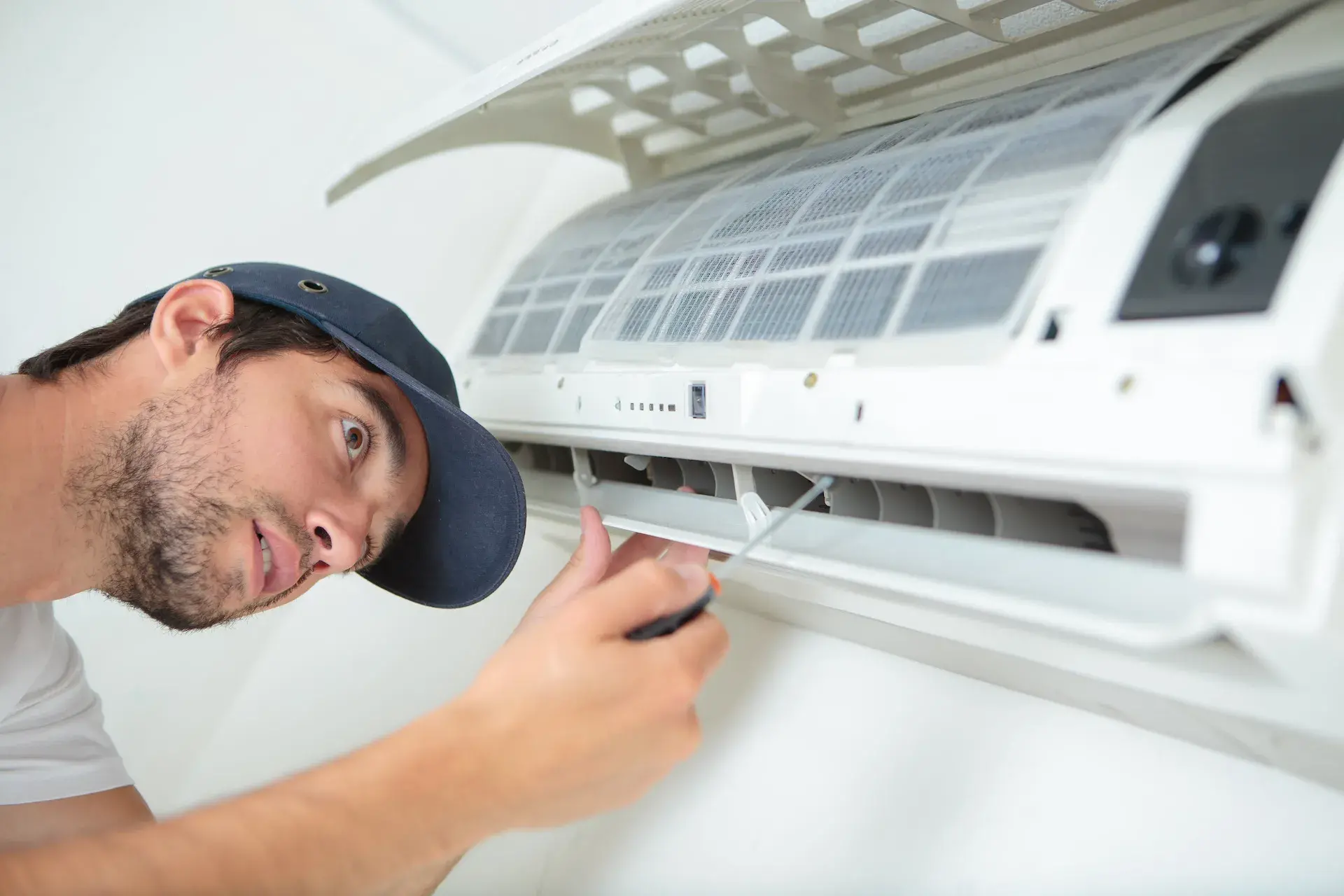 Technician servicing a wall-mounted air conditioning unit