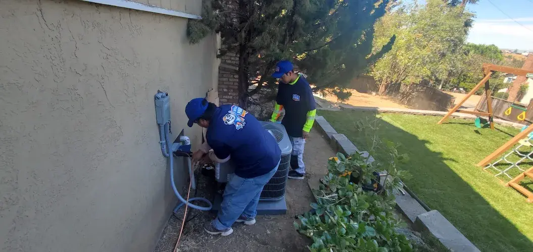Panda Heating & Cooling crew finishing an outdoor unit installation
