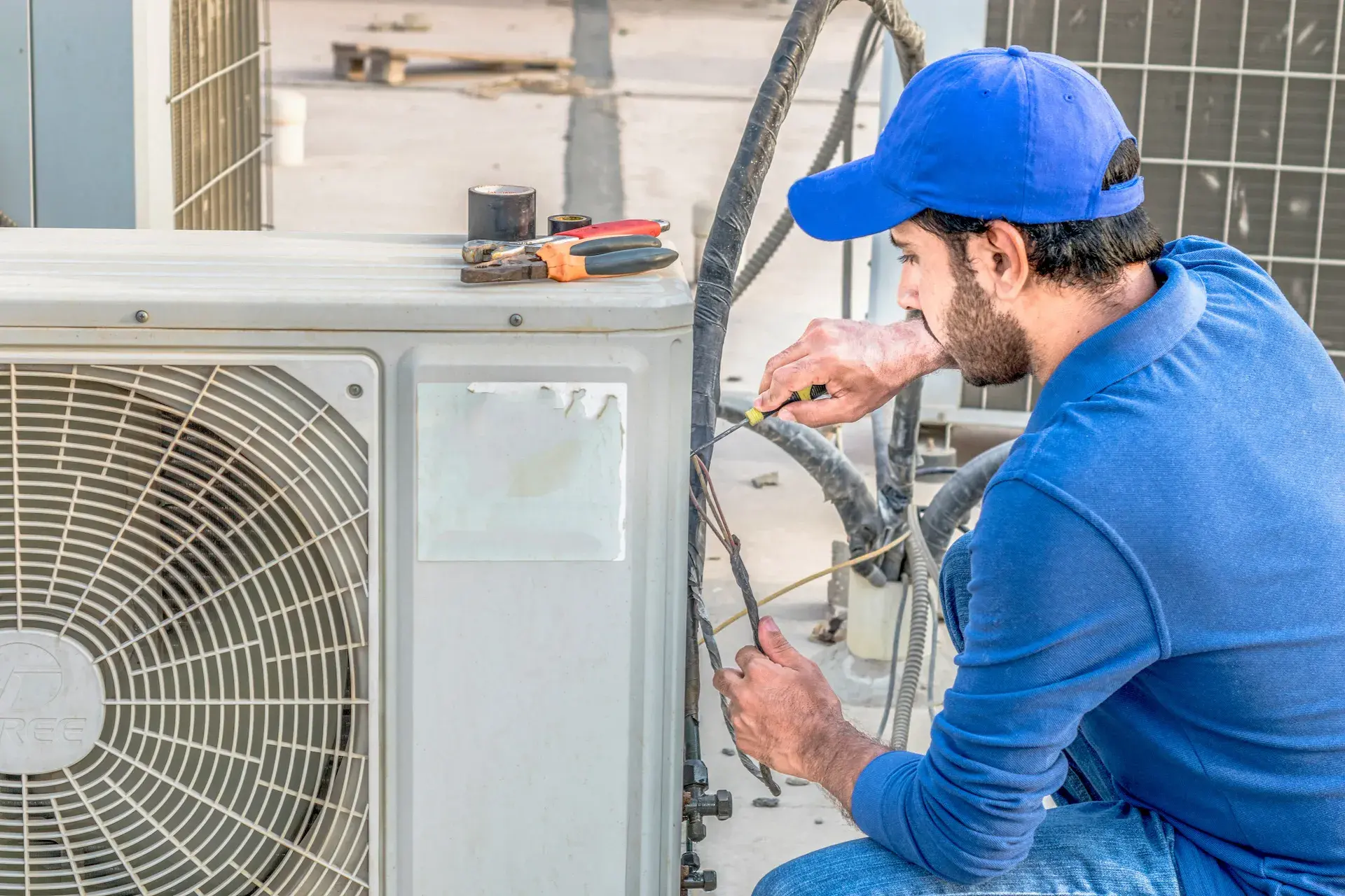 Technician repairing an outdoor air conditioning unit