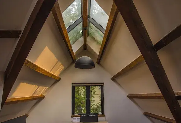 Bright converted attic room with a ceiling fan